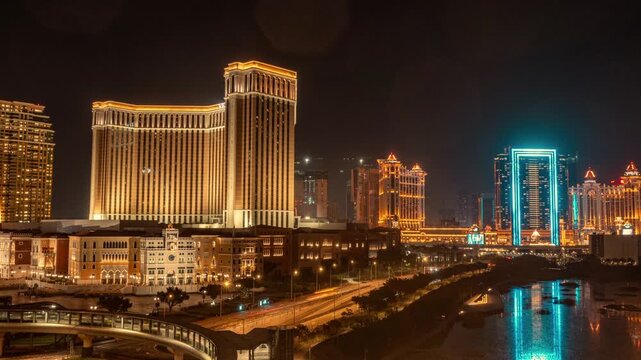 Illuminated Macau Cotai Strip Skyline at Night with Hotel Towers and Water Reflections