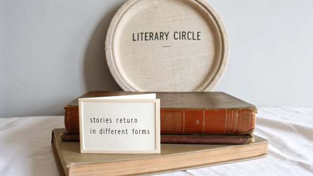 Old hardcover book with vintage literary circle sign and card featuring a quote