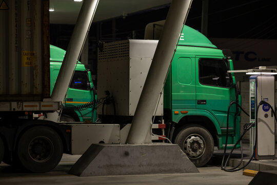 EV charging and semi truck electric vehicle, Electric vehicle semi truck trailer charging station for charge EV battery at night, EV charger semi truck trailer station at night.