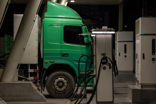 EV charging and semi truck electric vehicle, Electric vehicle semi truck trailer charging station for charge EV battery at night, EV charger semi truck trailer station at night.