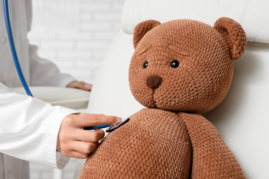 Pediatric healthcare and child wellness, doctor using stethoscope to examine teddy bear in medical clinic for comfort and anxiety reduction in children
