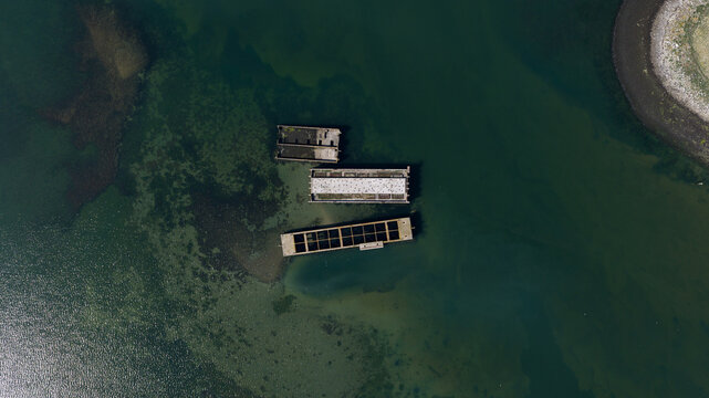 Aerial view of the historic Caissons Inlaag Schelphoek, remnants of flood defense structures resting in the clear coastal waters of Serooskerke Schouwen, Zeeland, Netherlands.