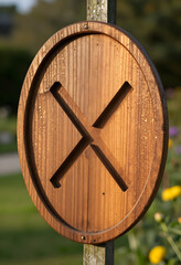 Fototapeta premium Prohibition and restriction concept, wooden sign with carved x mark for warning or cancellation, outdoor signage for safety and environmental guidance