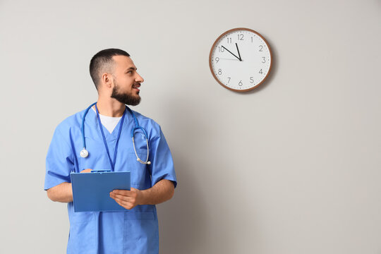 Healthcare time management and medical shift pressure, doctor looking at wall clock with clipboard in hospital office for patient appointment schedule