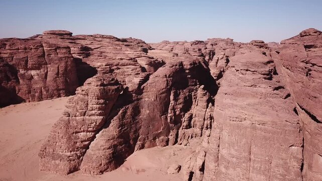 an expansive aerial view shows a sprawling desert landscape carved with deep canyons, rocky outcroppings, and sandy corridors stretching into the horizon.
