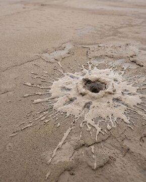 Sand boil caused by soil liquefaction on wet ground after earthquake