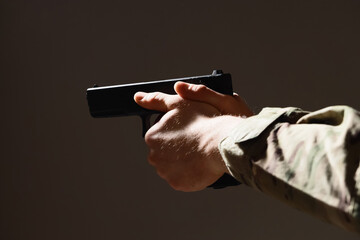 Obraz premium Armed conflict and military security, soldier holding a handgun in a tactical stance for combat training and defense operations in a dark environment