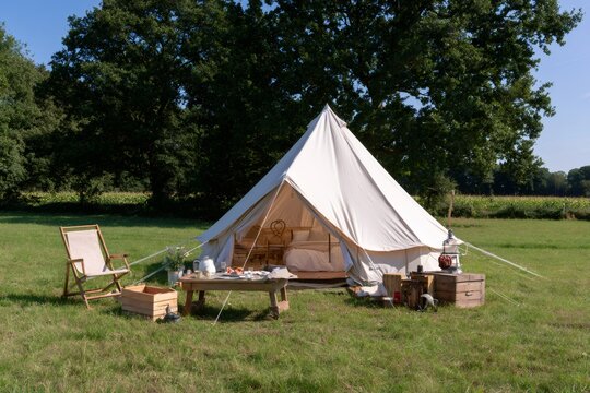 Glamping bell tent in green field during summer vacation