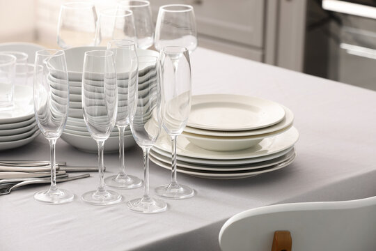 Event planning and catering service, clean white plates and empty champagne flutes arranged on a dining table for a formal celebration or banquet
