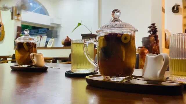 Traditional Vietnamese herbal tea sets with red dates and jasmine tea in ribbed glasses on wooden tables