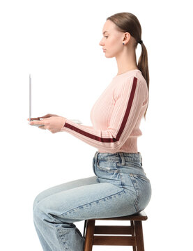 Remote work and digital nomad lifestyle, young woman using a laptop for freelance business and online communication while sitting on a wooden stool