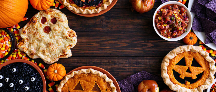 Halloween food halloween dessert pumpkin pie ghost pizza autumn table festive snack spooky treat party food candy corn caramel apple Halloween food and dessert rustic wood table with pumpkin pie