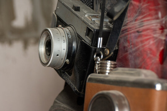 Close-up of vintage film camera with manual lens and leather strap in workshop.