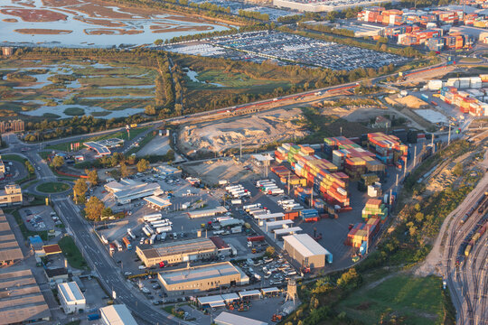 Aerial view of the Sermin industrial area and logistics hub, featuring rows of colorful shipping containers, warehouses, and transport trucks in Koper, Koper, Slovenia.