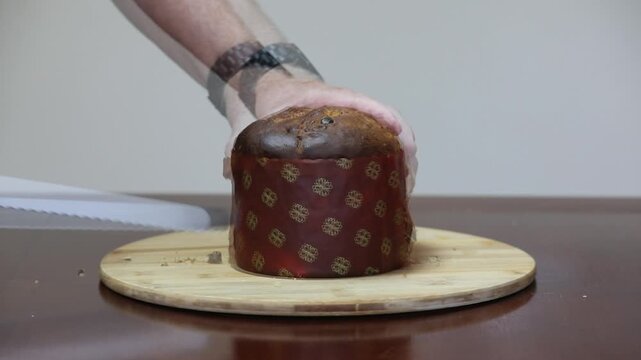 Cutting a traditional Italian artisan panettone with candied fruit.