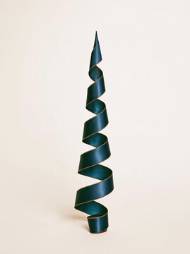 Ribbon spiral shaped like a christmas tree with a smooth satin texture and golden stitched edges, for festive decor and banner design