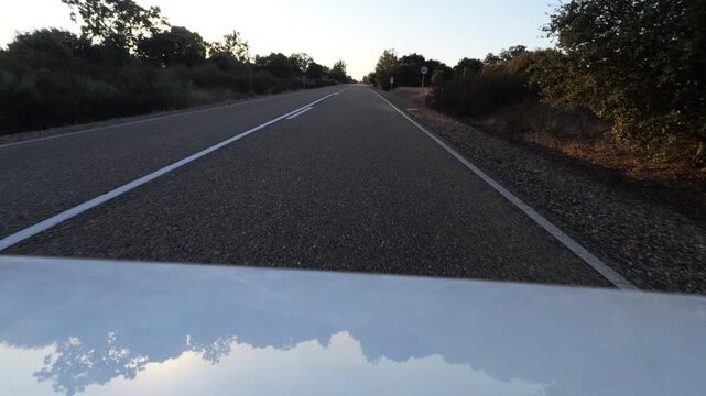 Driving Along Rural Asphalt Road at Sunset Glare