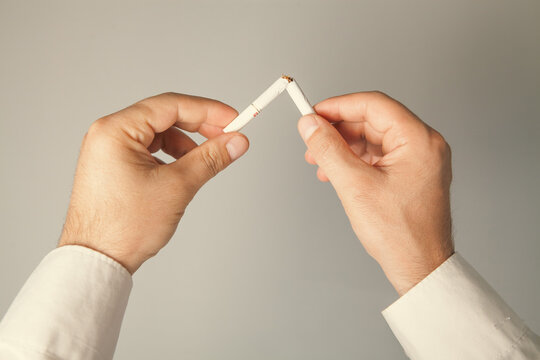 Man breaking a cigarette, close-up. Stop smoking concept.