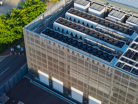 Aerial view of a data center roof featuring rows of industrial cooling fans and metallic mesh facade in the United Kingdom.
