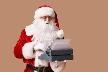 Obraz premium Santa Claus with vintage typewriter on brown background