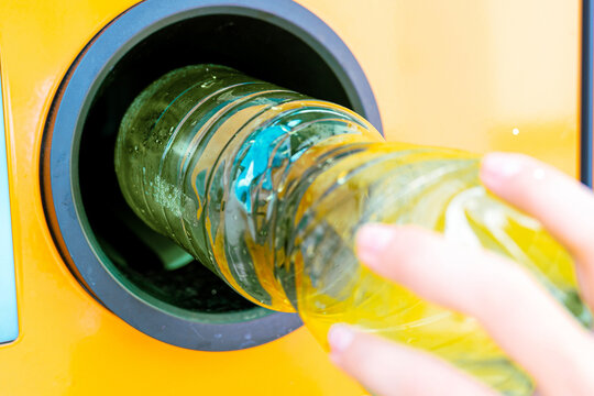Used plastic bottle entering deposit collection machine.