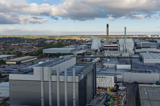 Aerial view of a large data center facility with cooling towers and industrial buildings surrounded by suburban landscape in the United Kingdom.