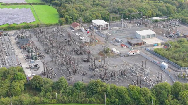 Large Electrical Substation Infrastructure Distributing Energy with nearby Solar Farm in Wales, UK.