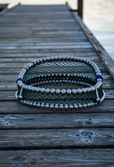 Fototapeta premium Sustainable aquaculture and commercial fishing, circular fish farming net with metal weights on a wooden pier for marine industry and seafood production