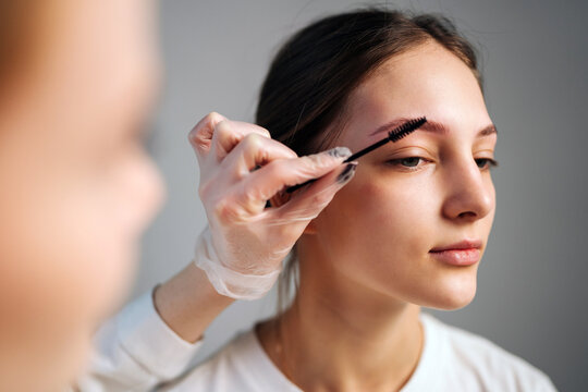 Woman receiving eyebrow grooming in a beauty salon during daytime