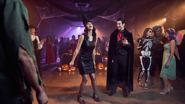 Halloween party dancing. Young people in costumes celebrate