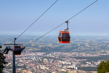Red Pohorje cable car cabins moving over Maribor valley © Michael Egenburg
