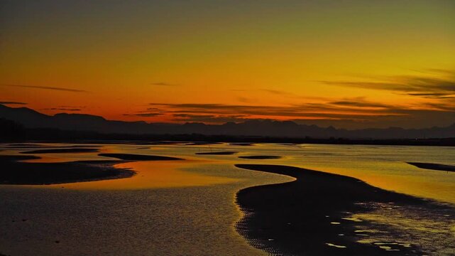 「日本の夕陽百選」に選ばれた大分県・真玉海岸の干潟に美しく反射する黄金色の夕焼け空とリフレクション
