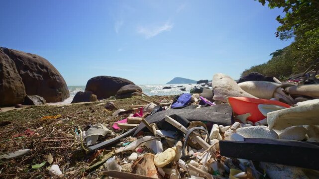 Plastic waste and garbage washed up on tropical rocky beach