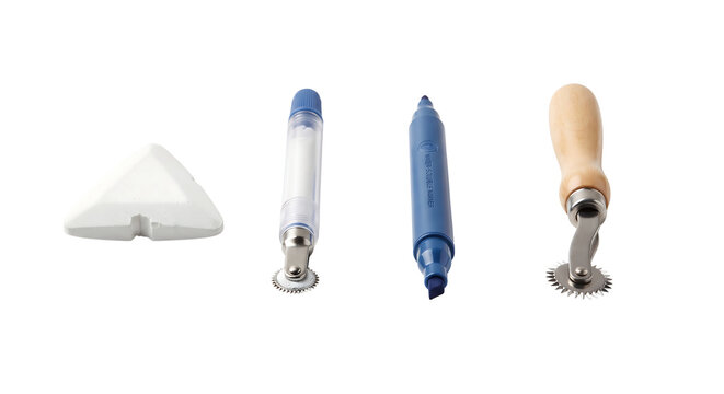 Collection of sewing and crafting marking tools including tracing wheels and chalk on white background with tracing wheel white background