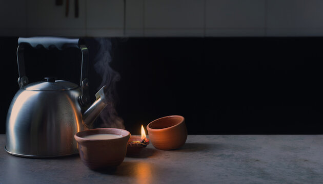 Chai steam and a single new diya on a pre-dawn Diwali kitchen counter