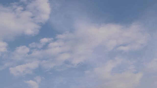 Sky with thin light white clouds in the daytime, natural background, space, height. Clear blue sky with thin, scattered white clouds. Minimalist landscape. View from below on a natural blue sky
