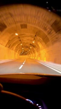 A car travels along a road at night and enters a tunnel. The route runs from Nice, France, towards Genoa, Italy.