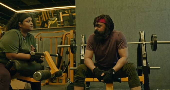Fitness Athlete Performing Bench Press With Trainer Coaching and Support &mdash; Determined man completes chest workout sets using a bench press and rope exercise while a personal trainer provides guidance 