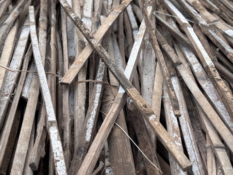 Background of pile of split dry bamboo sticks for traditional construction and handicraft material. Natural eco friendly bamboo texture backdrop template with copy space for banner design.