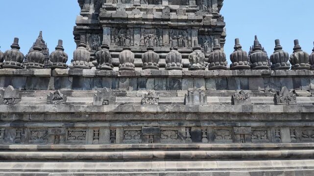 Ancient stone relief carvings and architectural stupa details at Prambanan temple, historical heritage site in Indonesia with intricate sculptural craftsmanship, travel photography
