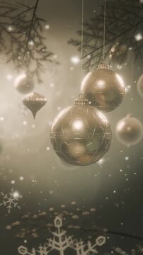 Vertical video: Pulling back revealing gold baubles swaying on pine at festive scene with snow