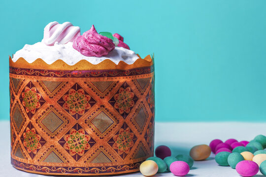 Traditional Easter cake, colorful candy eggs. Kulich (paska) decorated white frosting
