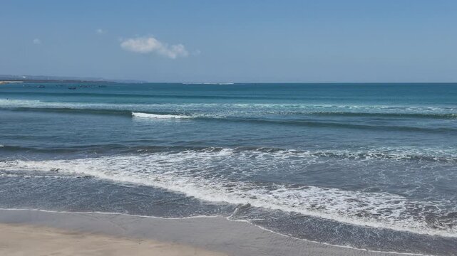 Gentle ocean waves crashing onto sandy beach at Karimunjawa island, tropical coastline with turquoise water, relaxing sea scenery, nature background, refreshing summer atmosphere and tranquility