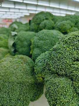 Macro close-up of fresh green broccoli florets at the supermarket shelf

