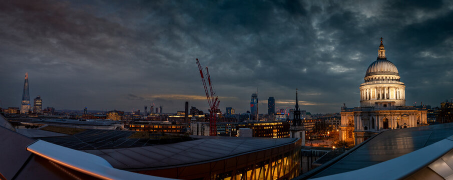 London cityscape view with st paul's cathedral and the shard under a dramatic sky at twilight