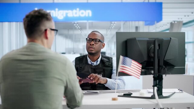 Immigration Officer Carefully Verifies Man's Passport During Busy US Border