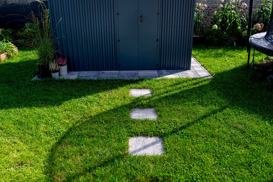 Garden stepping stones leading to dark shed