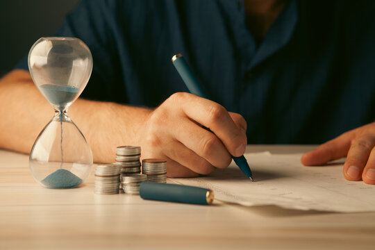 man with calculator and coins on table, closeup