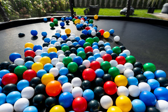 Colorful plastic balls filling a trampoline for play