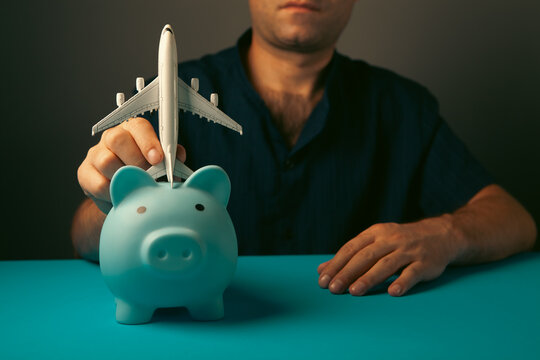 A piggy bank and an airplane in a person's hand.